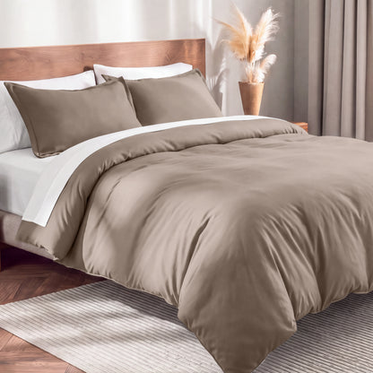Flannel duvet cover set on a bed in a bedroom with a lamp and plant in the background.