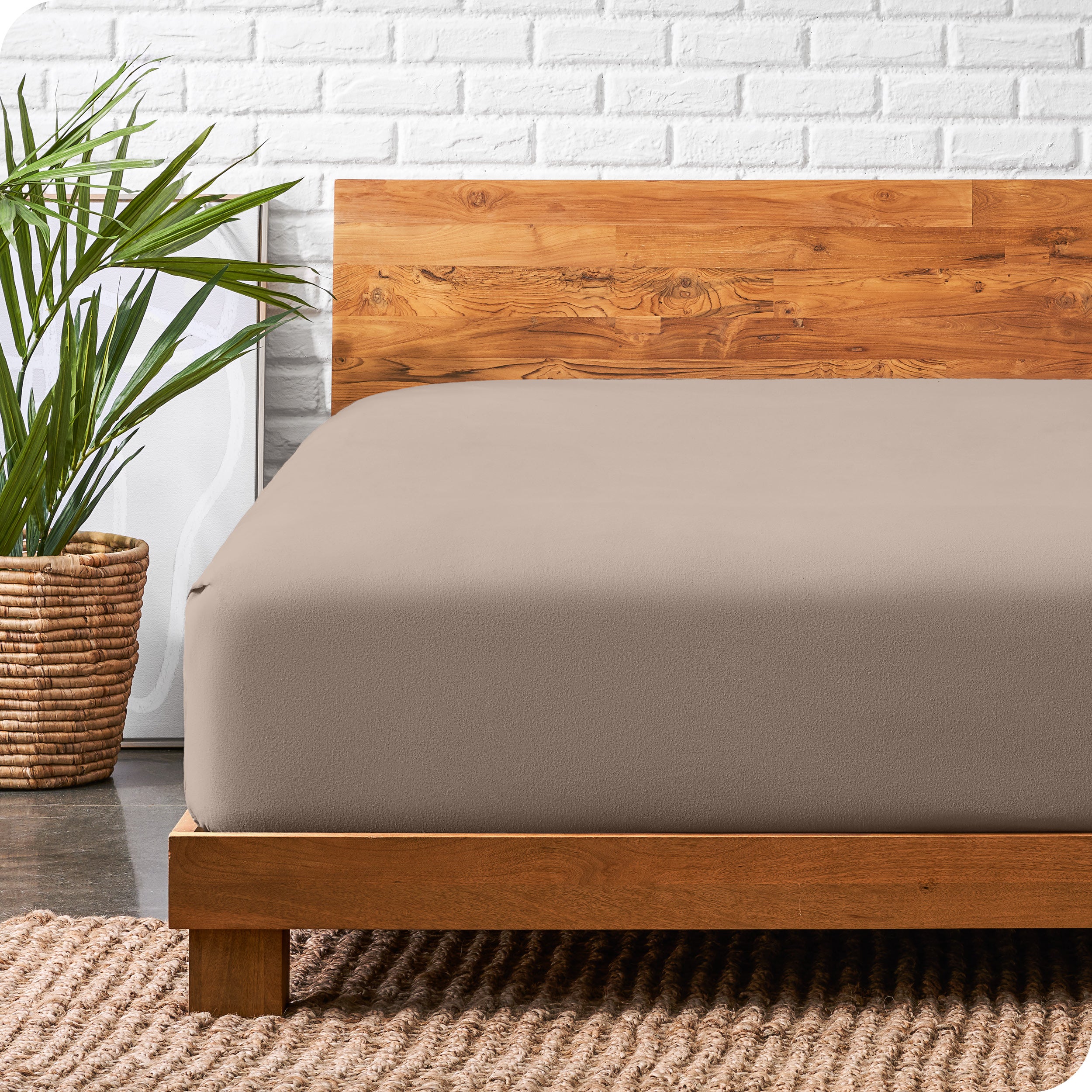A modern bed with a wooden bed frame with a flannel fitted sheet on.