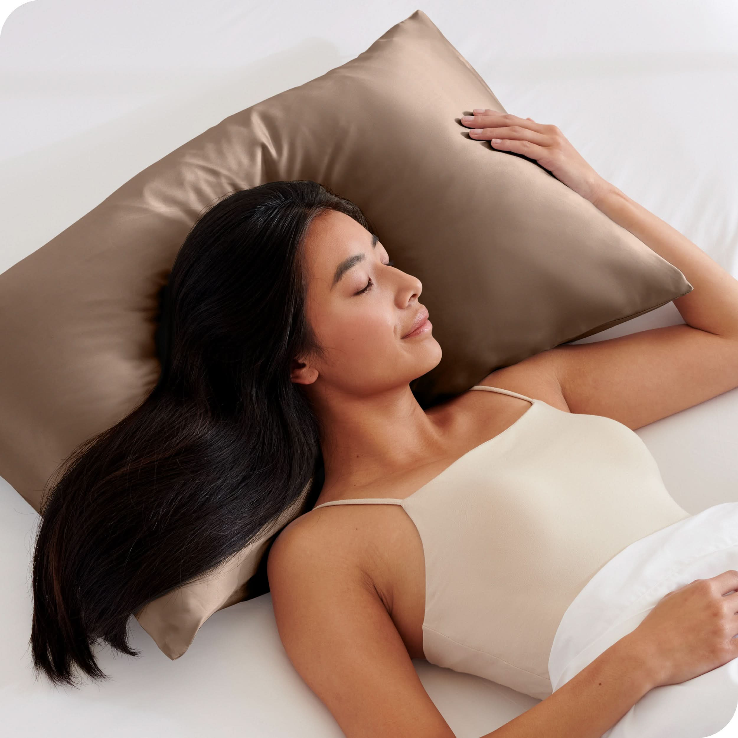 A woman is sleeping with her head on a silk pillowcase