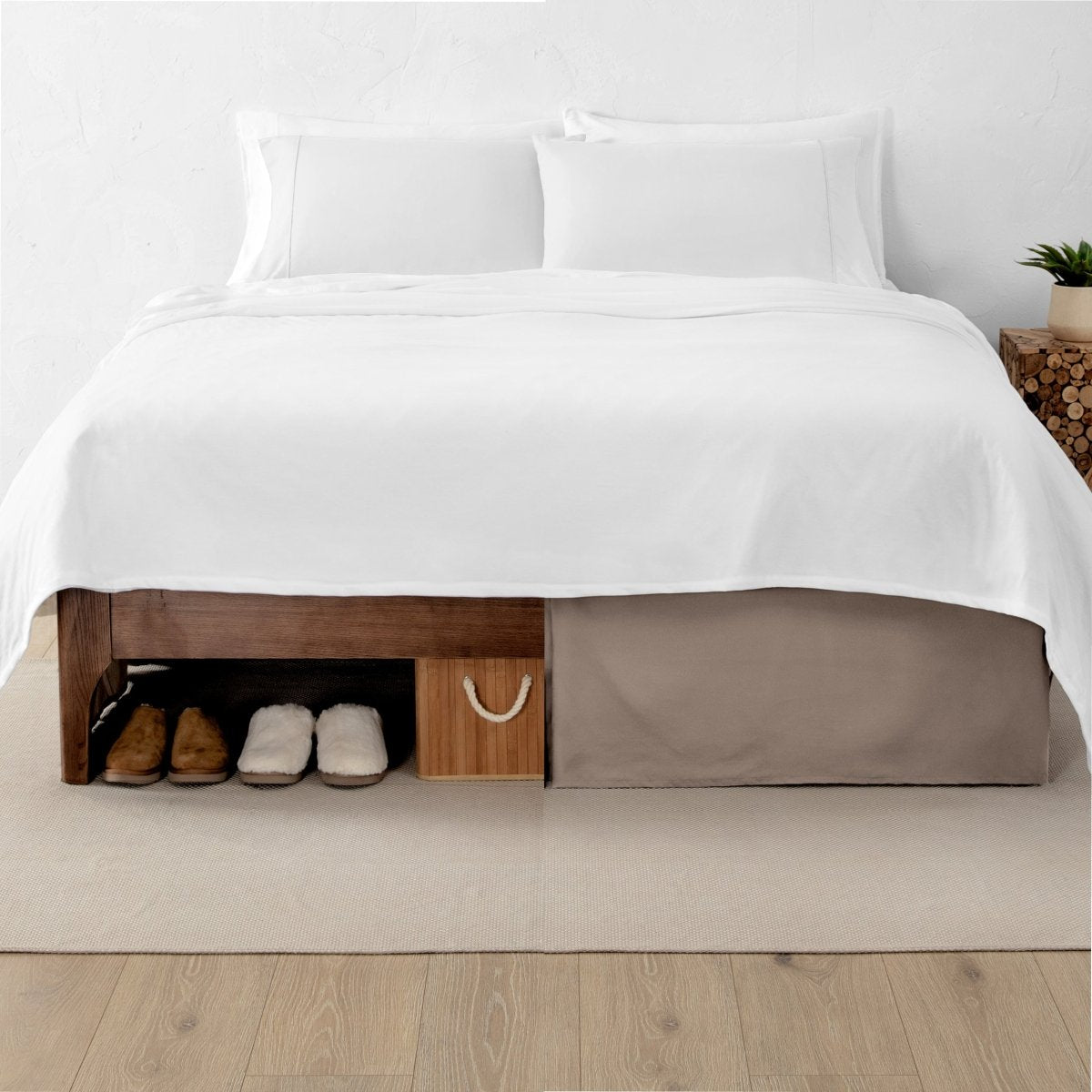 One side of a bed has shoes and a box under it while the other side has a bed skirt so that under the bed is hidden from view