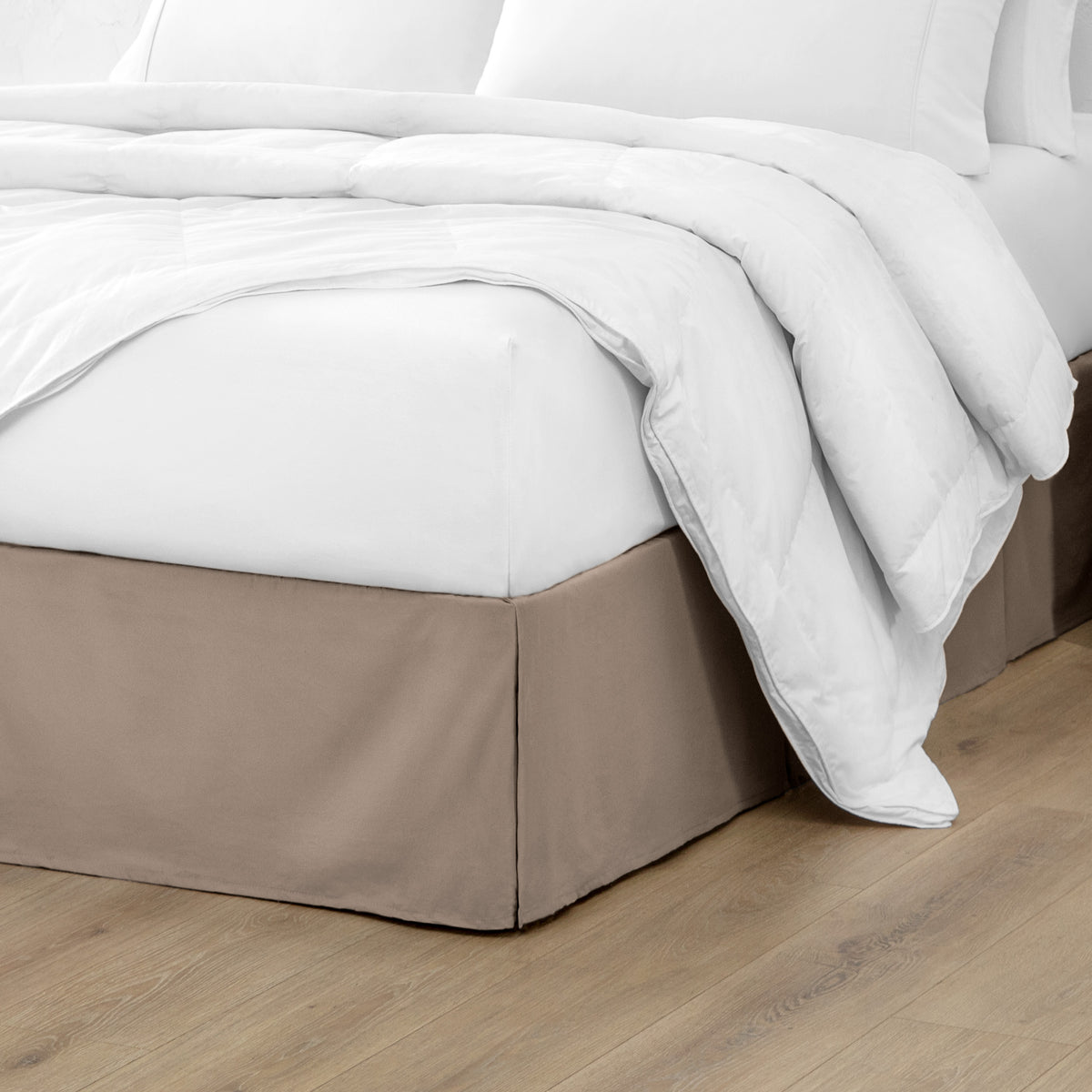 Microfiber bed skirt on a bed with white bedding and wooden floor.