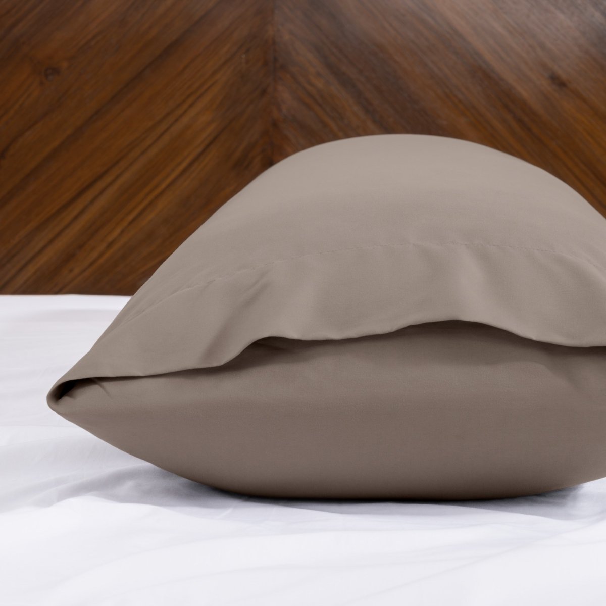 Body pillowcase with an envelope closure on a bed with a wooden headboard