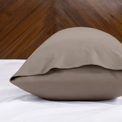 Body pillowcase with an envelope closure on a bed with a wooden headboard