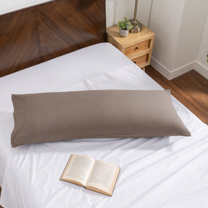 Pillowcase on a body pillow with a wooden headboard and plant in the background