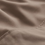 A close-up of microfiber fabric with soft folds and a visible stitched seam.