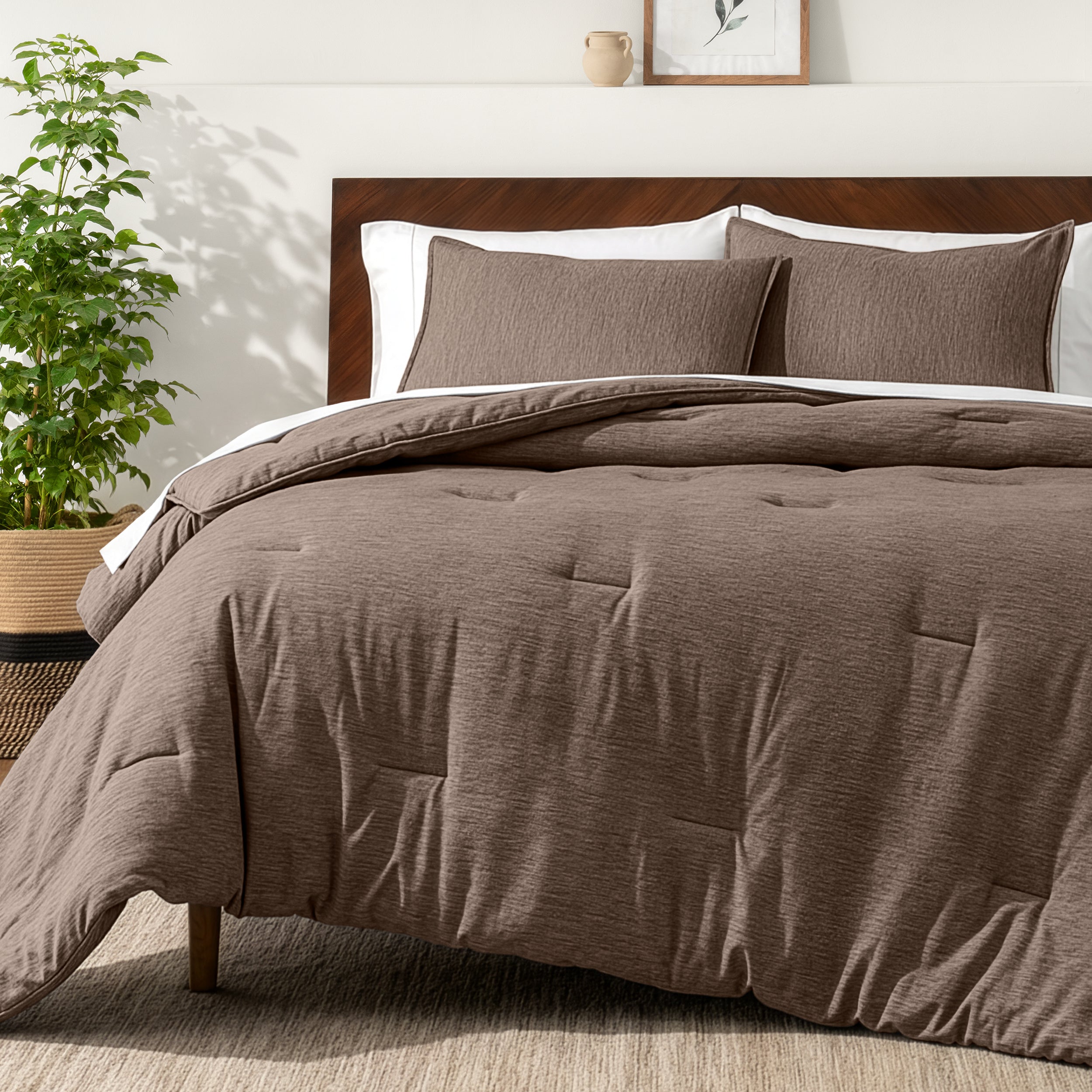 Bedding set on a bed in a bedroom with a side table and lamp.