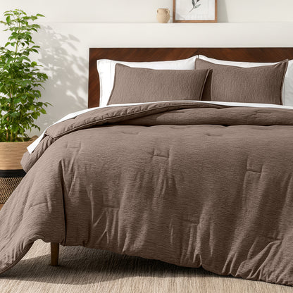 Bedding set on a bed in a bedroom with a side table and lamp.