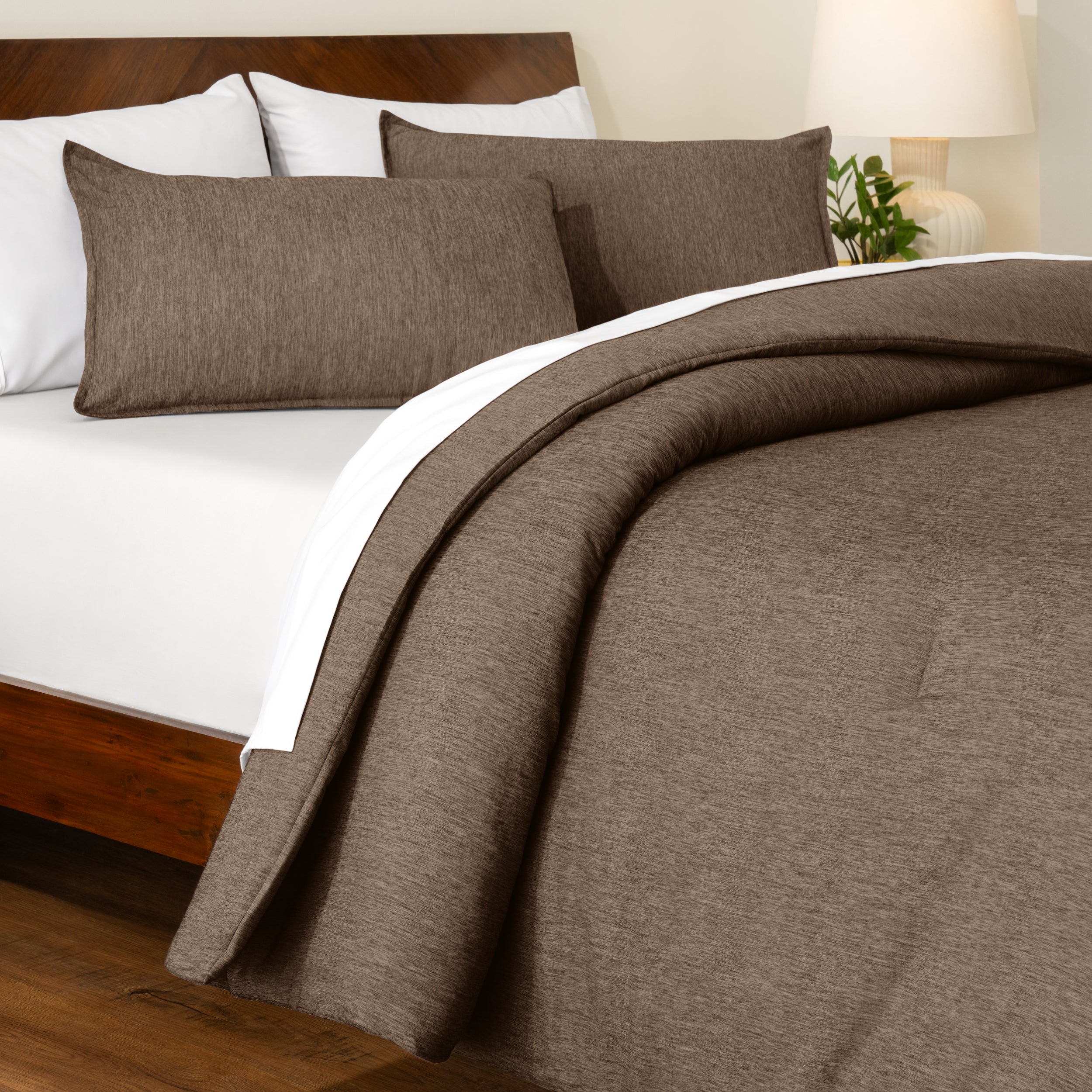 Track stitch comforter on a bed with white pillows and a wooden headboard.