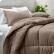 A side view of a modern bed with a comforter set and pillows on the bed