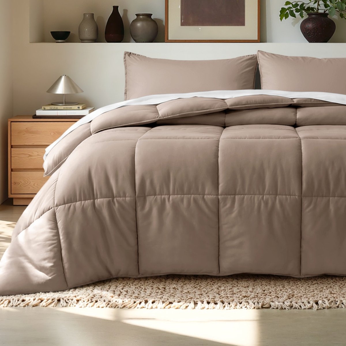 Comforter on a bed in a bedroom setting with a wooden nightstand and decorative items.