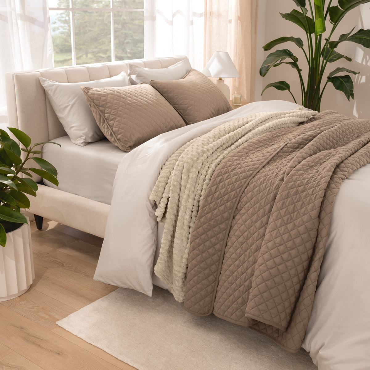 Side view of bed with coverlet set draped on a bed made with a duvet set