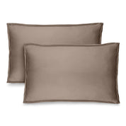 Two taupe pillow shams on pillows standing up with one behind the other
