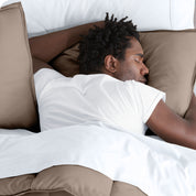 Man sleeping with his head resting on a pillow sham