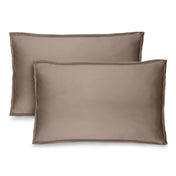 Two brown pillow shams on pillows standing up with one behind the other