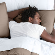 Man sleeping with his head resting on a pillow sham