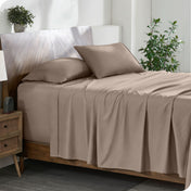 A cozy bedroom featuring a neatly made bed with soft, microfiber sheets.