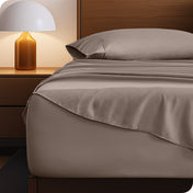 Microfiber bed sheets on a neatly made bed with a wooden headboard and nightstand.
