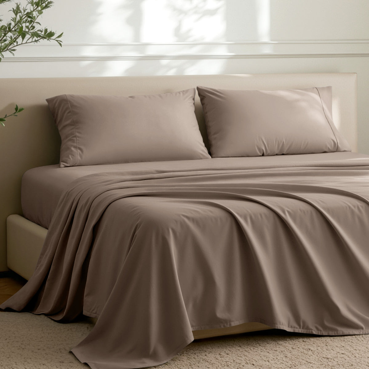 Microfiber sheets on a bed in a well-lit room with a plant.