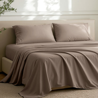 Microfiber sheets on a bed in a well-lit room with a plant.