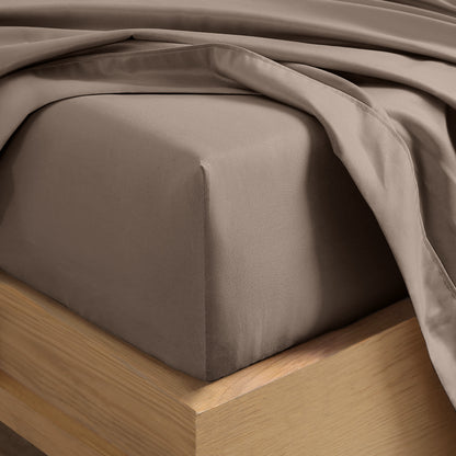 Close up of the corner of a mattress with a fitted sheet and flat sheet on it