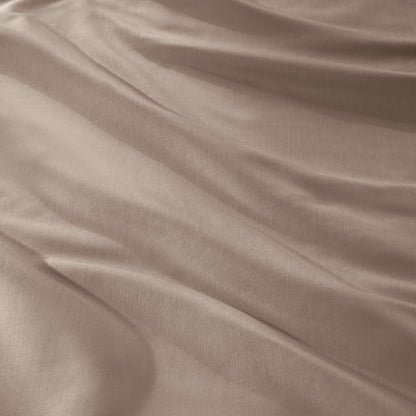 A close-up of draped sateen fabric with soft folds and a smooth texture.