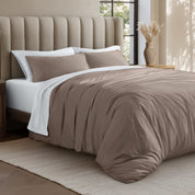 Bed with jersey duvet set against a beige headboard.