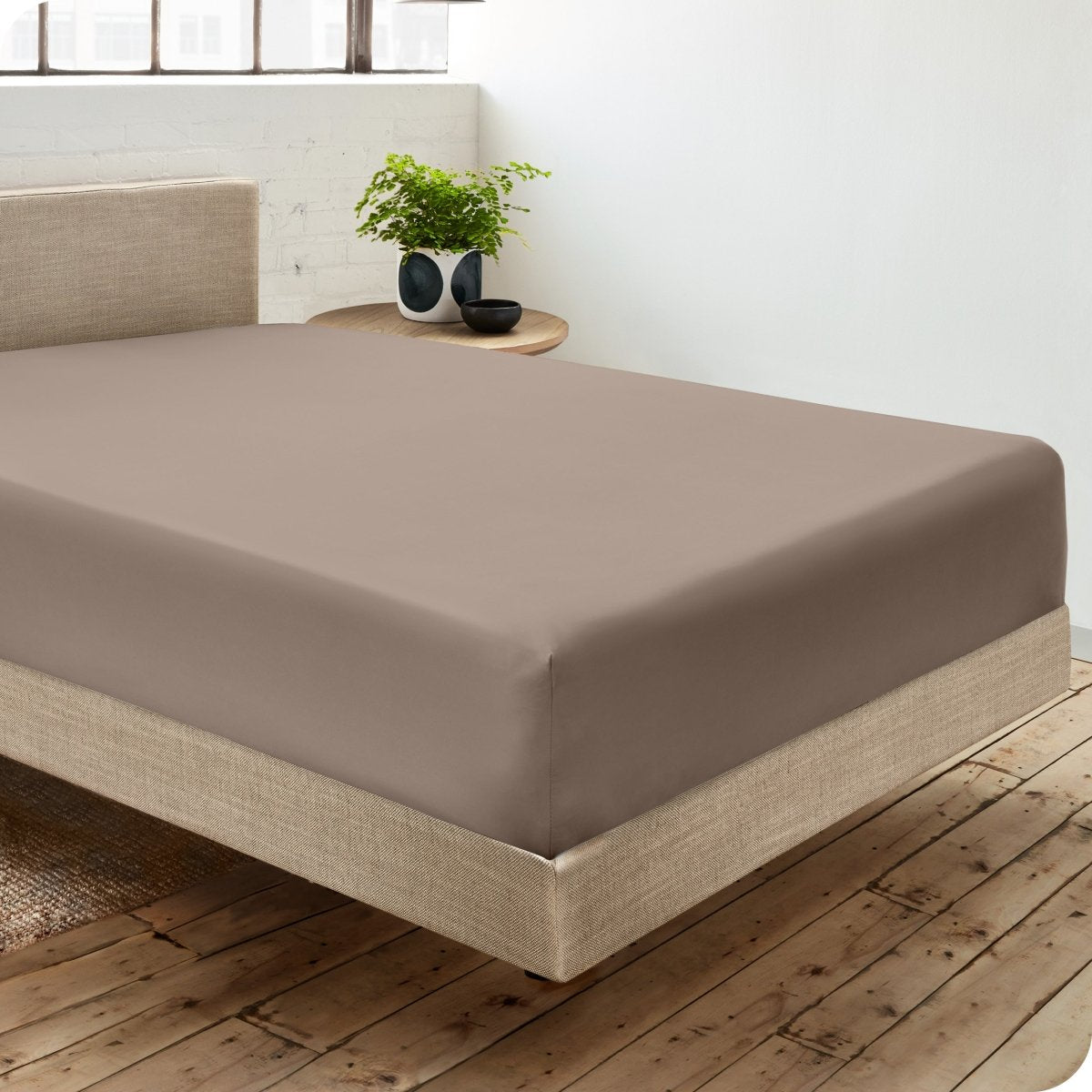Diagonal view of room scene with percale fitted sheet on the bed