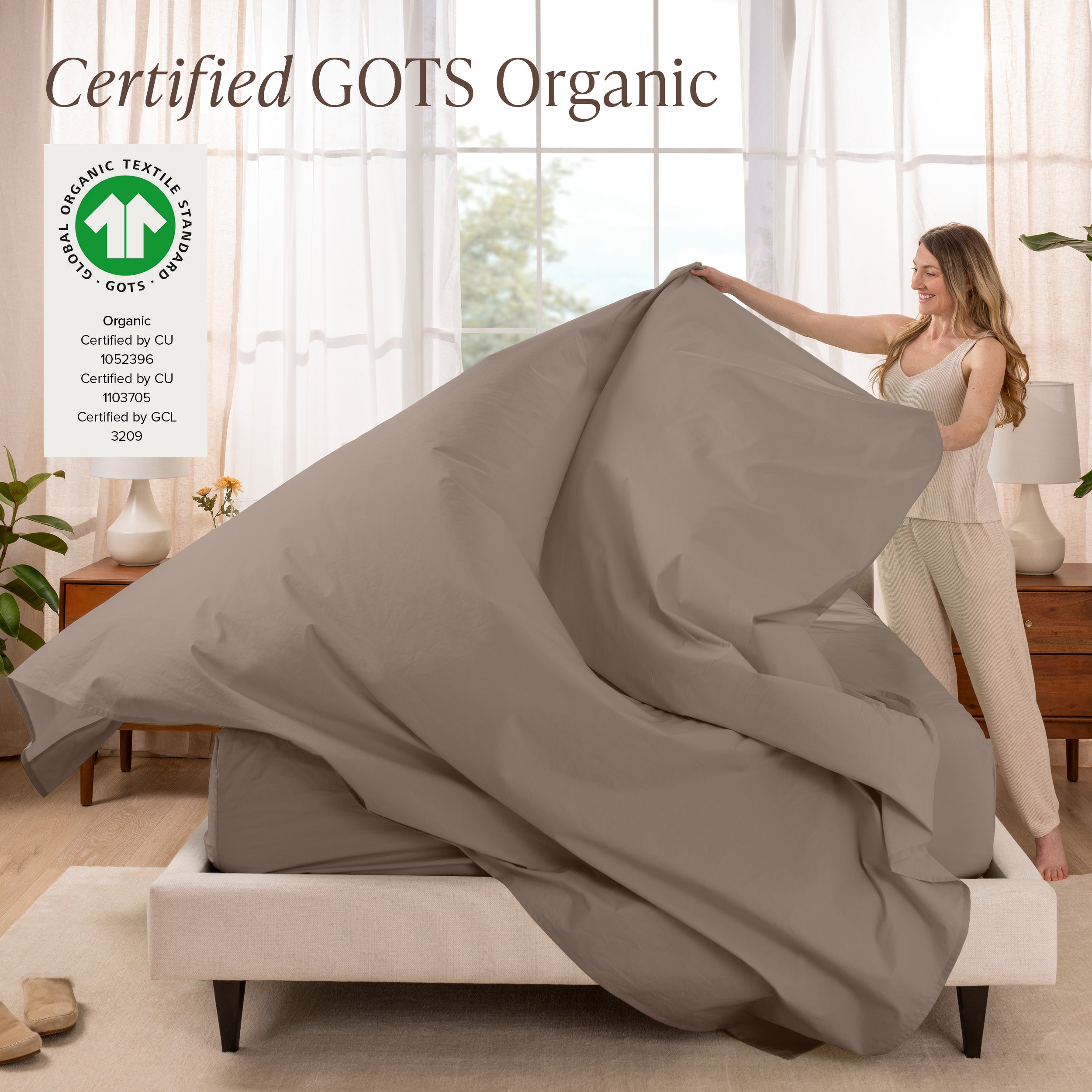 A woman is making a bed with organic cotton percale sheets