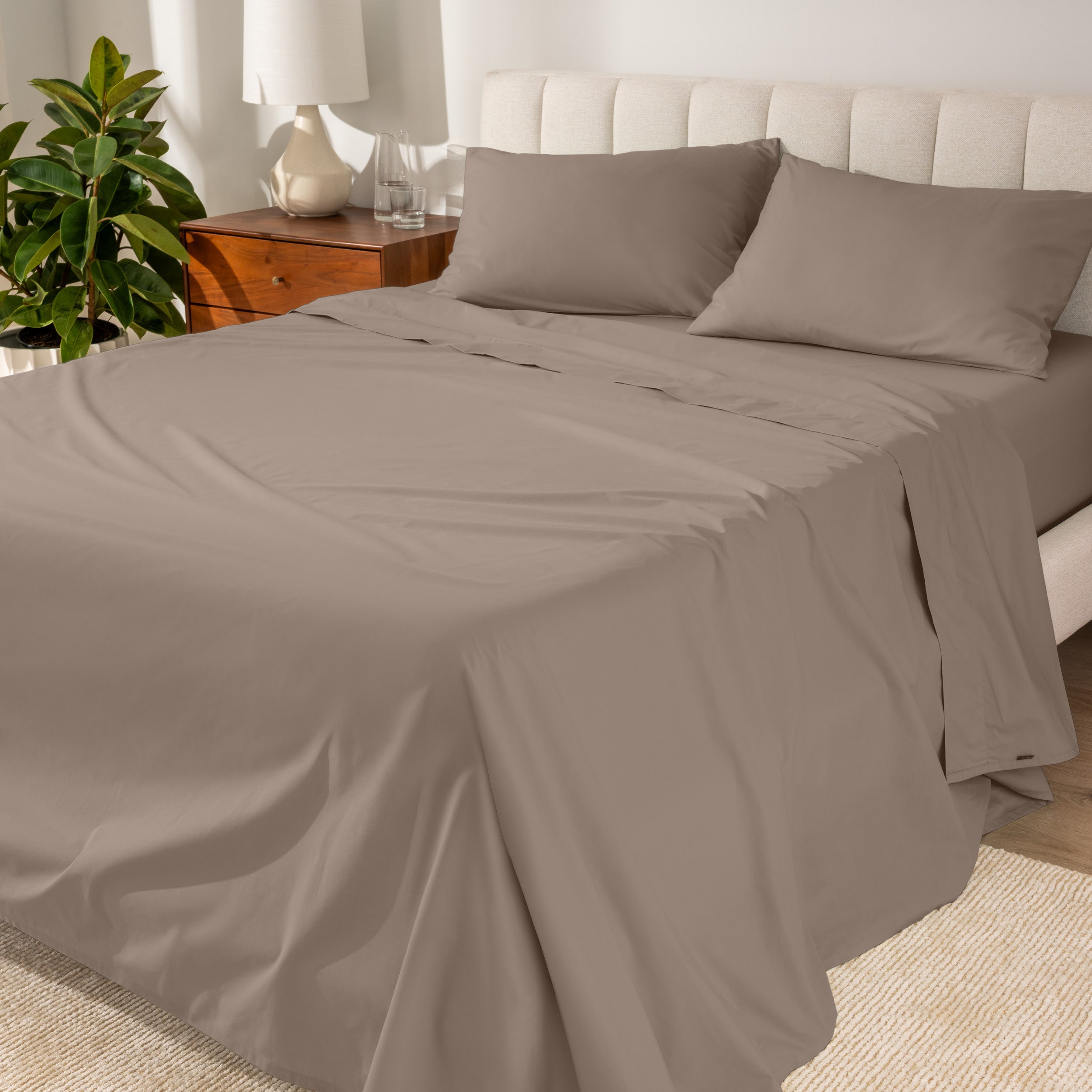 Percale sheets on a bed with a cream colored frame and headboard
