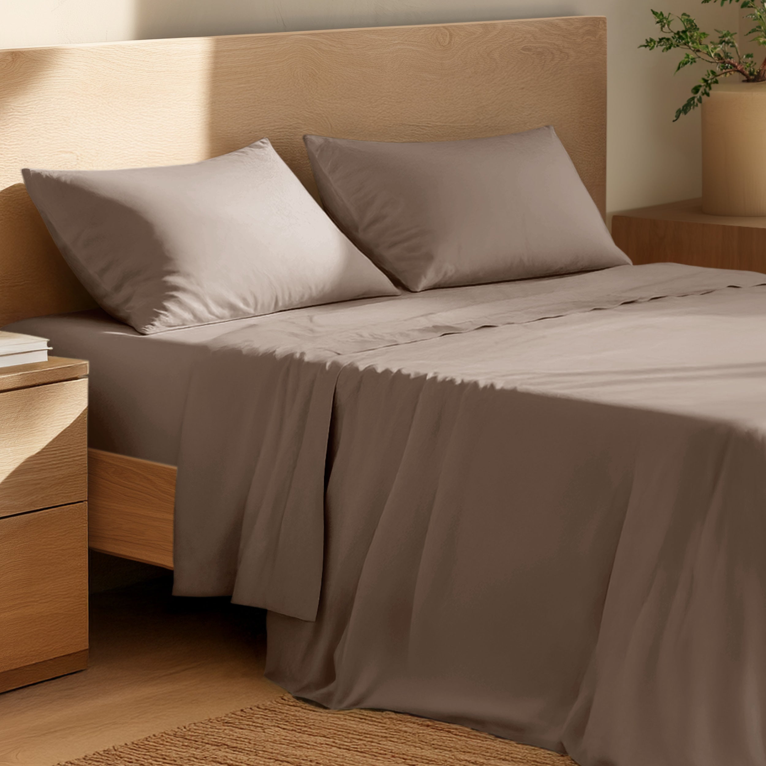 Bed with percale bedding and wooden headboard in a bedroom setting
