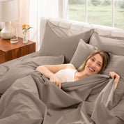 Woman lying in bed with percale bedding in a bright bedroom