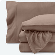 Fleece sheets folded neatly and stacked with pillows inside the pillowcases