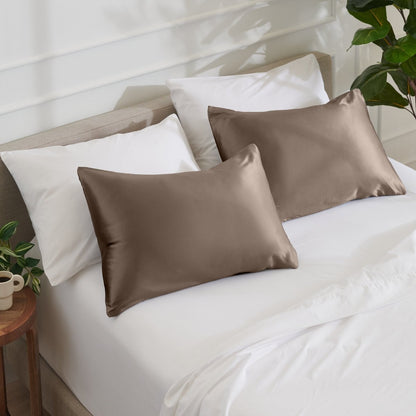 Satin pillowcases on a bed with white bedding