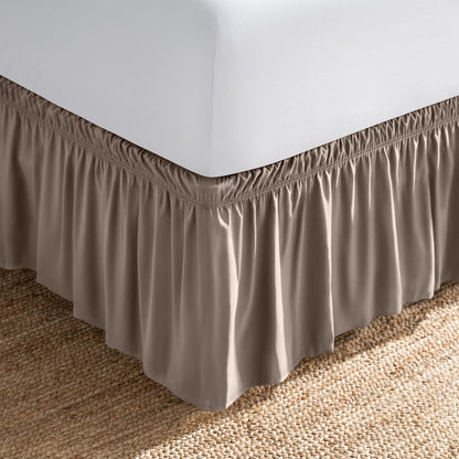 Bed with white fitted sheet and an adjustable bed skirt.