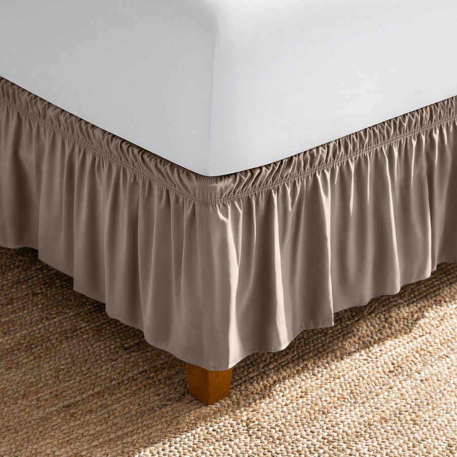 Bed with white fitted sheet and an adjustable bed skirt.