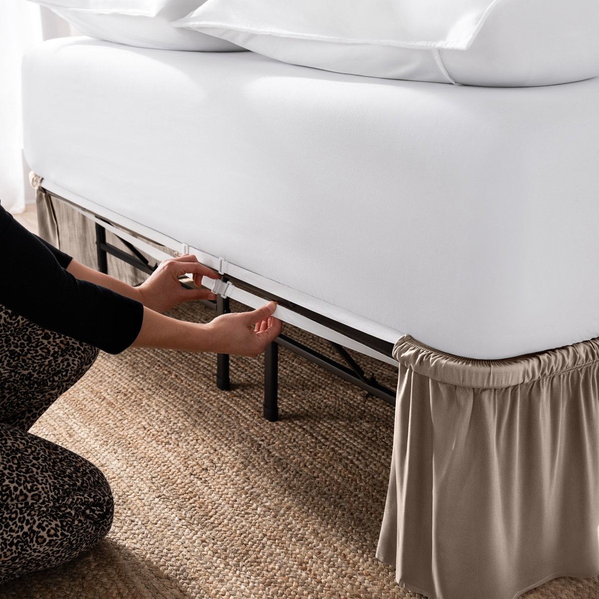 Adjustable bed skirt on a bed showing the elastic strap.
