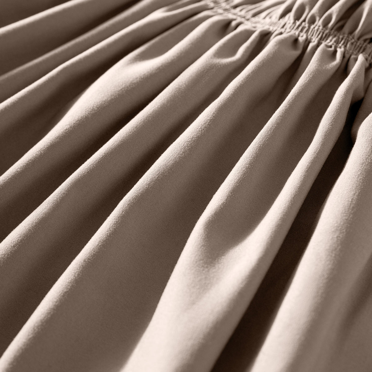 Close-up of polyester bed skirt fabric with a focus on texture and folds.