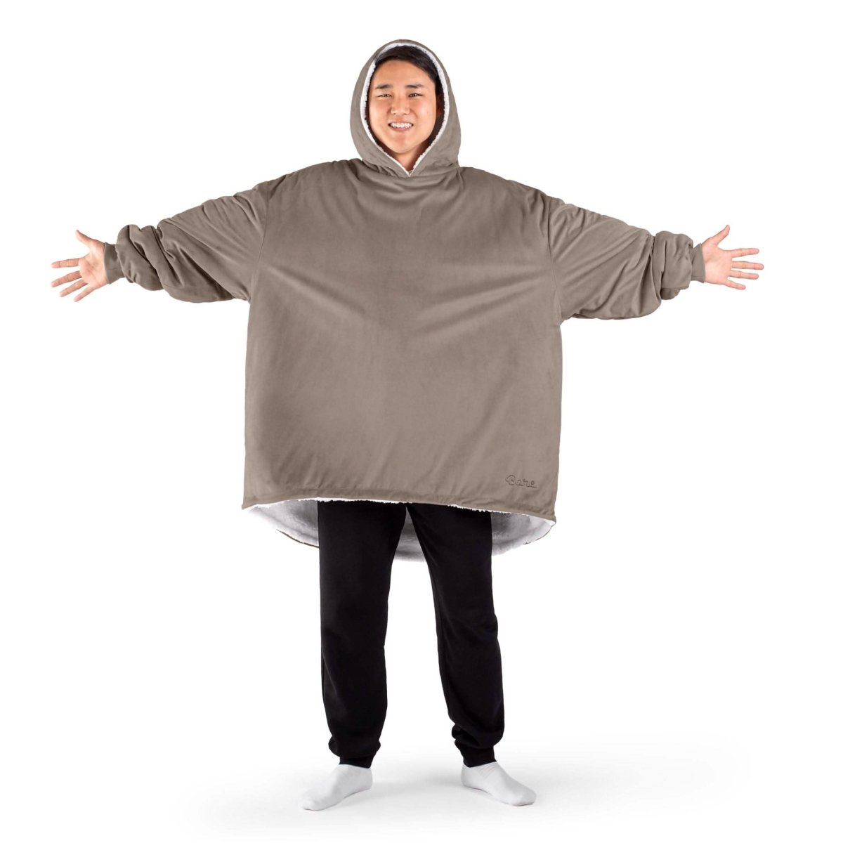 An adult with a sherpa wearable blanket on
