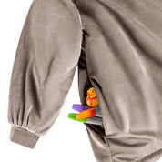 Close up of 1 pocket on the wearable blanket. Some markers and toys are sticking out of the pocket.