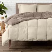 A wooden bed frame with a reversible comforter and sheet set on the mattress