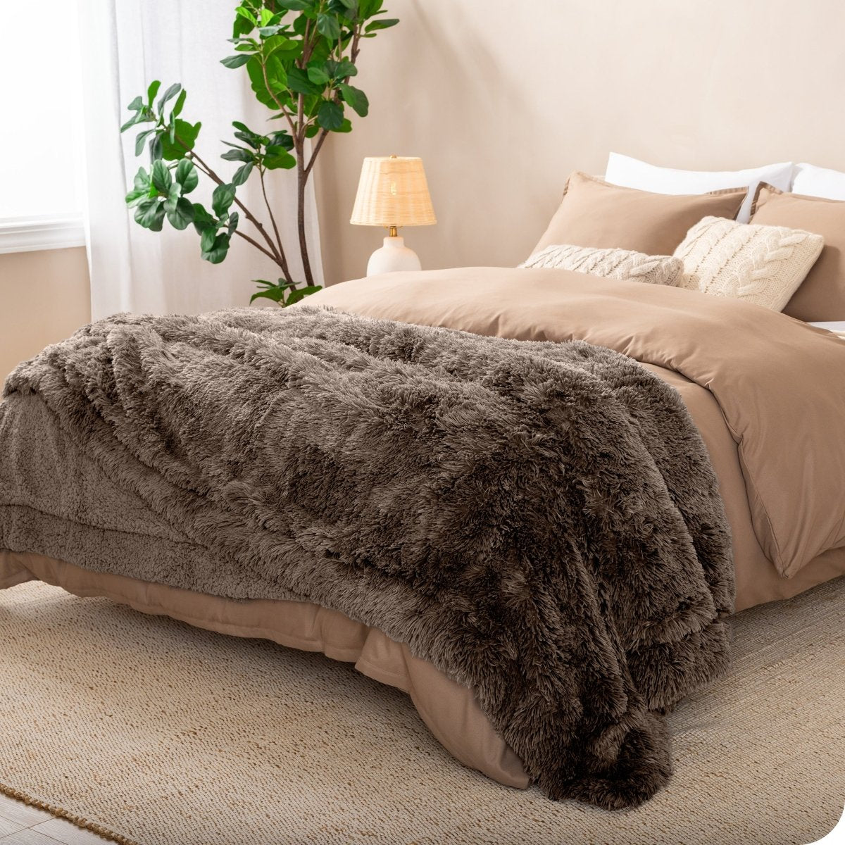 A shaggy faux fur blanket on the end of a bed