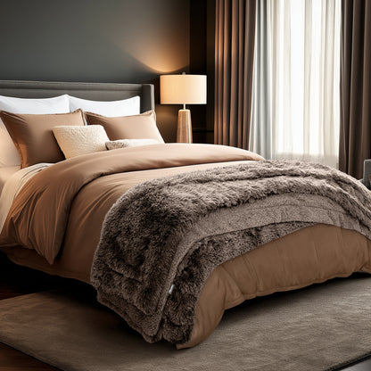 Neatly made bed and a textured throw blanket  over the end of the bed.