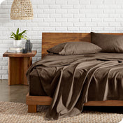 Microfiber sheets on a bed with a wooden headboard