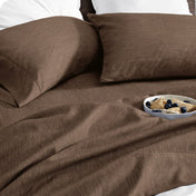 Bedding set on a bed with a bowl of cereal on a white background
