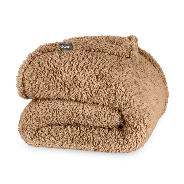 Folded textured blanket with a brand label on a white background