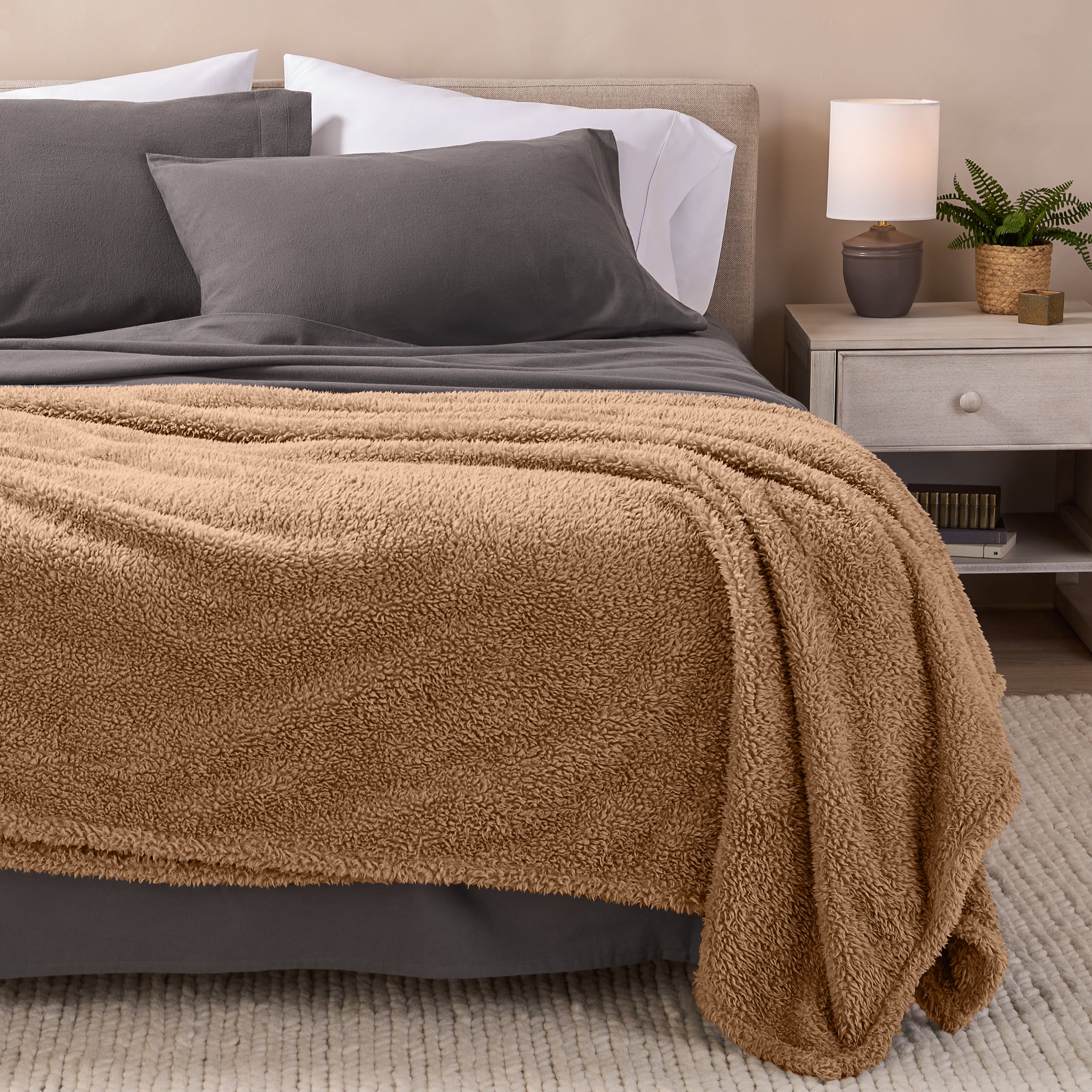 A double sided sherpa blanket on a bed