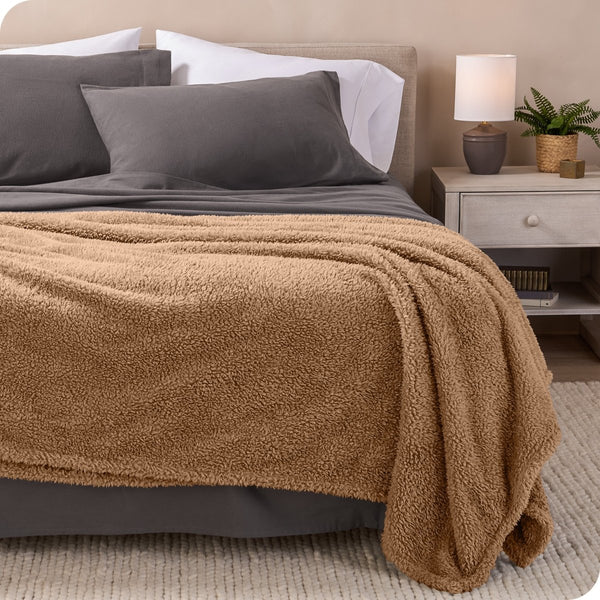 A double sided sherpa blanket on a bed