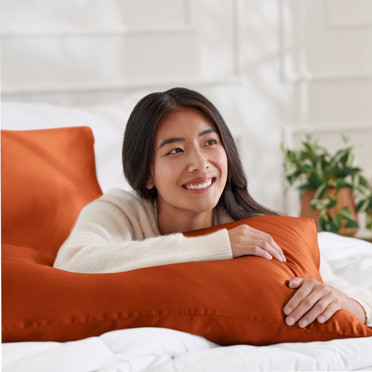 Woman lying on abed with a silk pillowcase