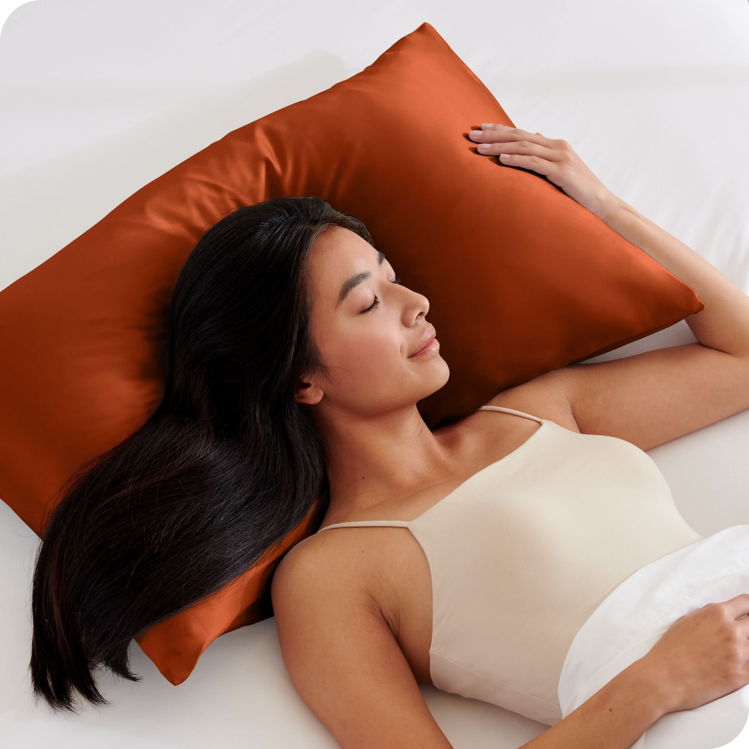 A woman is sleeping with her head on a silk pillowcase