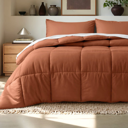 Comforter on a bed in a bedroom setting with a wooden nightstand and decorative items.